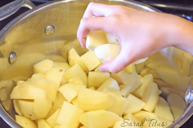 Placing cubed potatoes in a pot for a Craveworthy Potato Salad