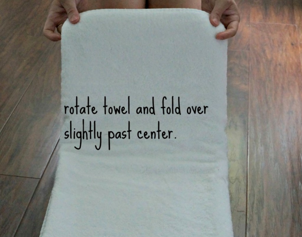 Female holding a towel showing how to fold it