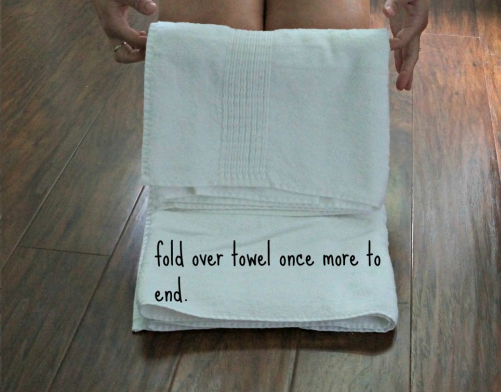 Female holding a towel showing how to fold it