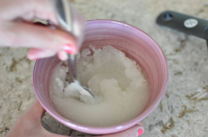 Stirring together the sugar and Fractionated Coconut Oil in a mixing bowl