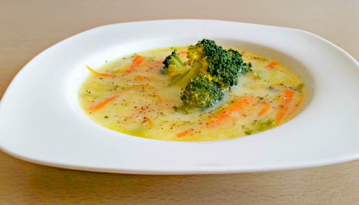 Appetizing Greek Avgolemono Vegetable Soup in a white bowl on a wood table