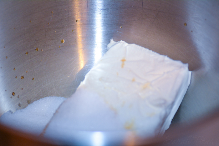 Cream cheese, sugar and vanilla in a silver mixing bowl