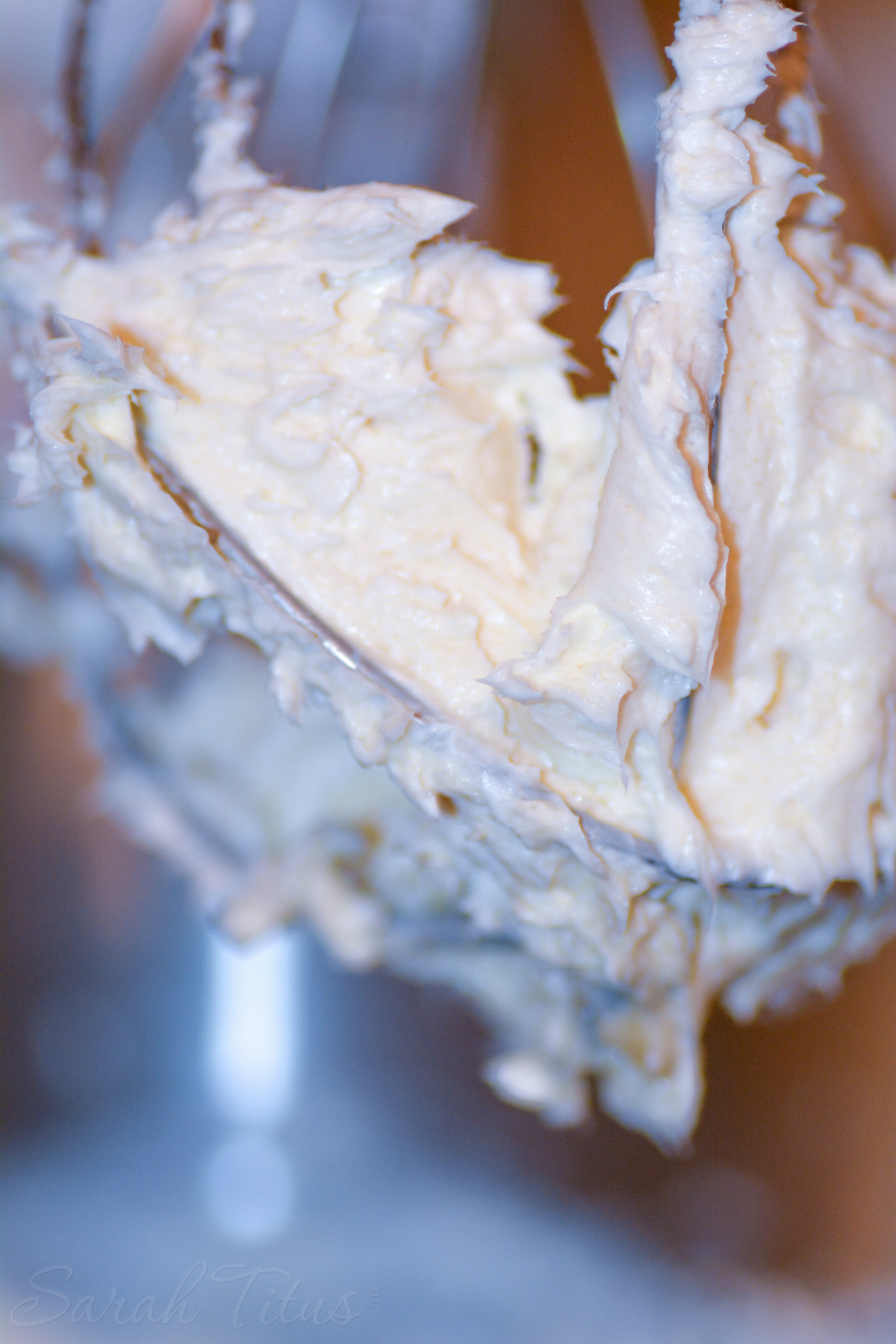 Whipped cream cheese, sugar and vanilla in a silver mixing bowl