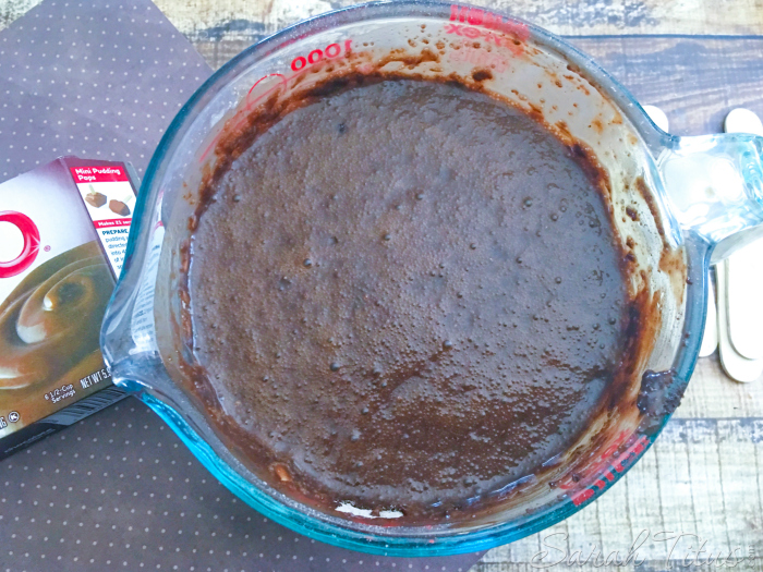 The mixed pudding and milk mixture in a large glass measuring cup