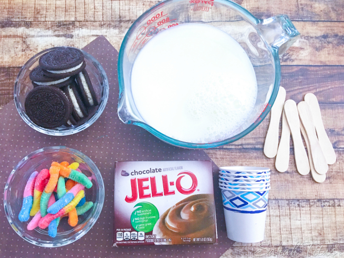 Mud Pie Pudding Pops' ingredients of oreo type cookies, milk, chocolate pudding, gummy worms, Dixie cups and ice cream spoons