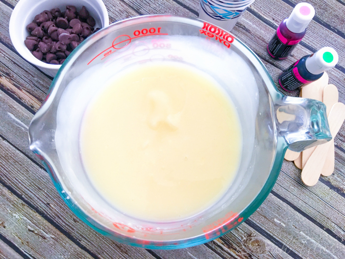 Mixed pudding and milk mixture surrounded by other Watermelon Pudding Pops supplies