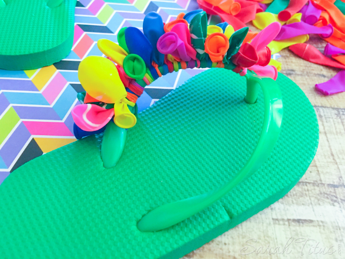 Continuing to tie colorful balloons on to the green flip flop straps for the Balloon Flip Flops