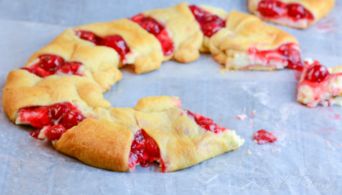 Scrumptious looking Cherry Cheesecake Crescent Ring on a parchment lined baking sheet