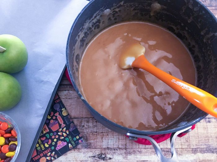 The luscious looking finished caramel sauce in a sauce pan on a wooden table