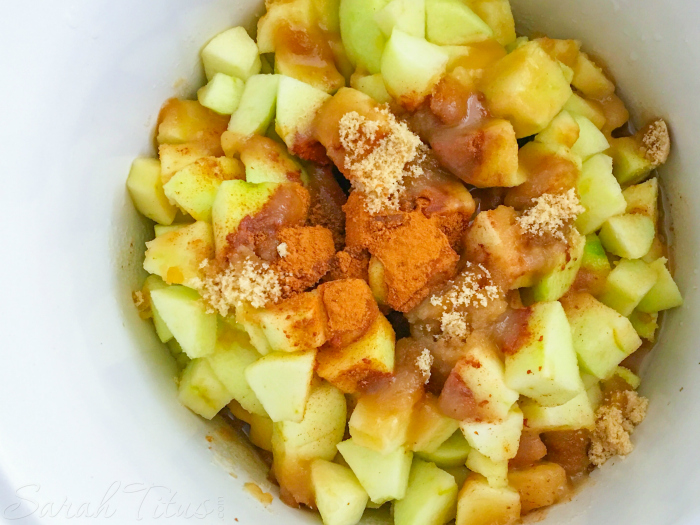 Water poured over top of the apples and seasoning in a bowl