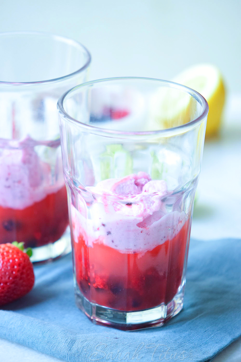 2 Scoops of ice cream over top of the berries and juice in glasses