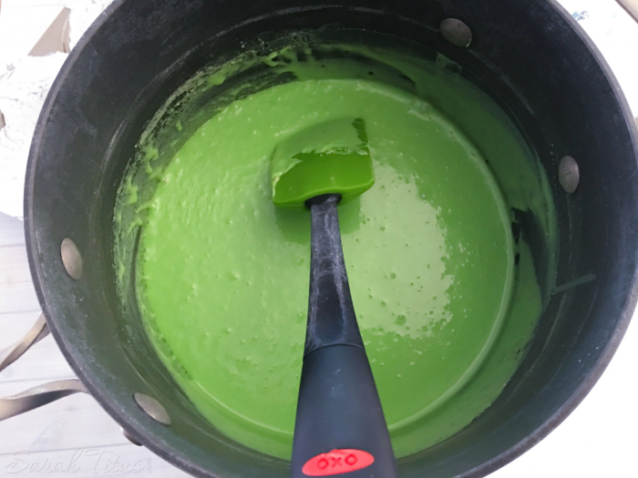 Stirring green melting candy, vanilla and milk in a saucepan