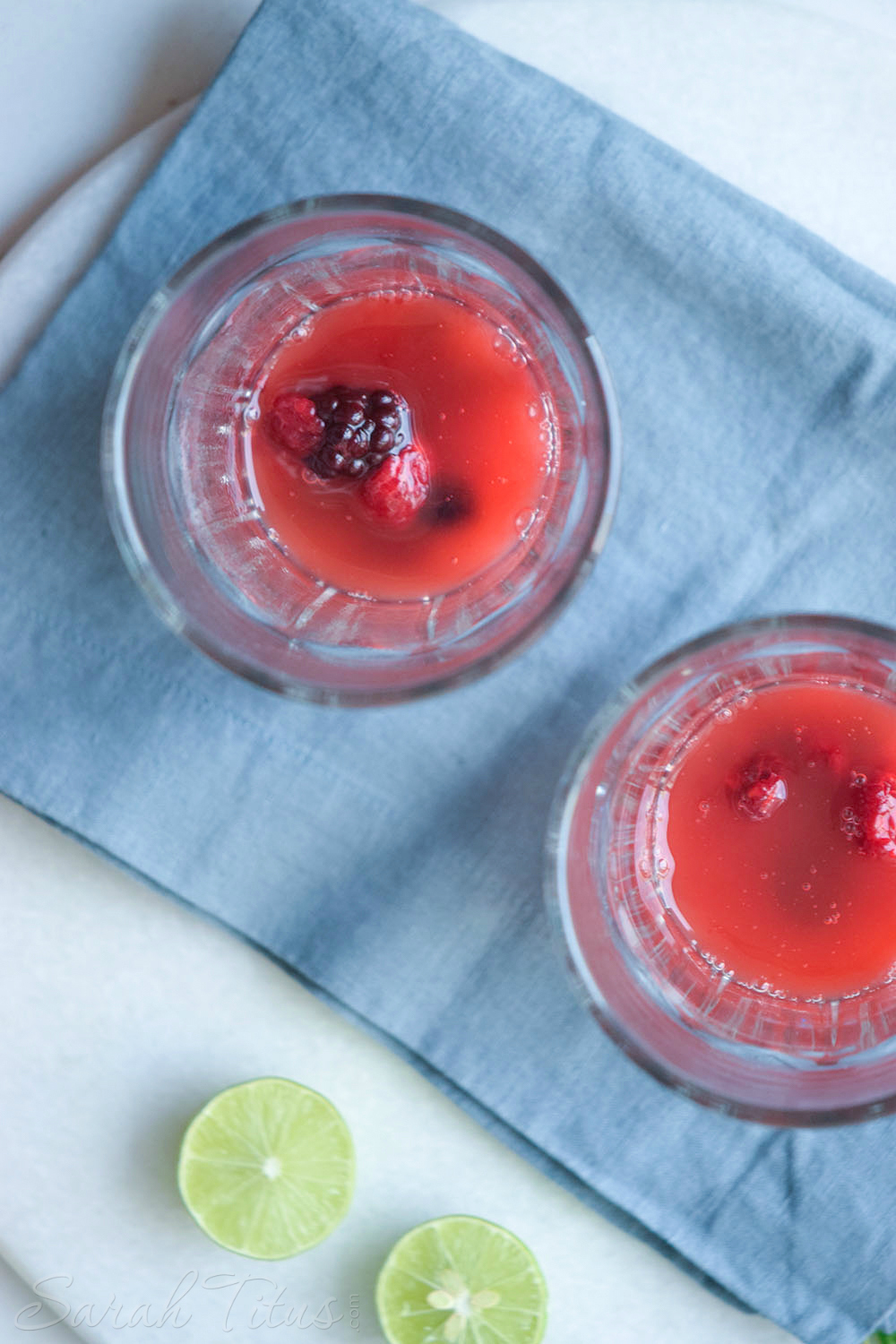 Strawberry juice poured over raspberries, blueberries, and blackberries in a glass