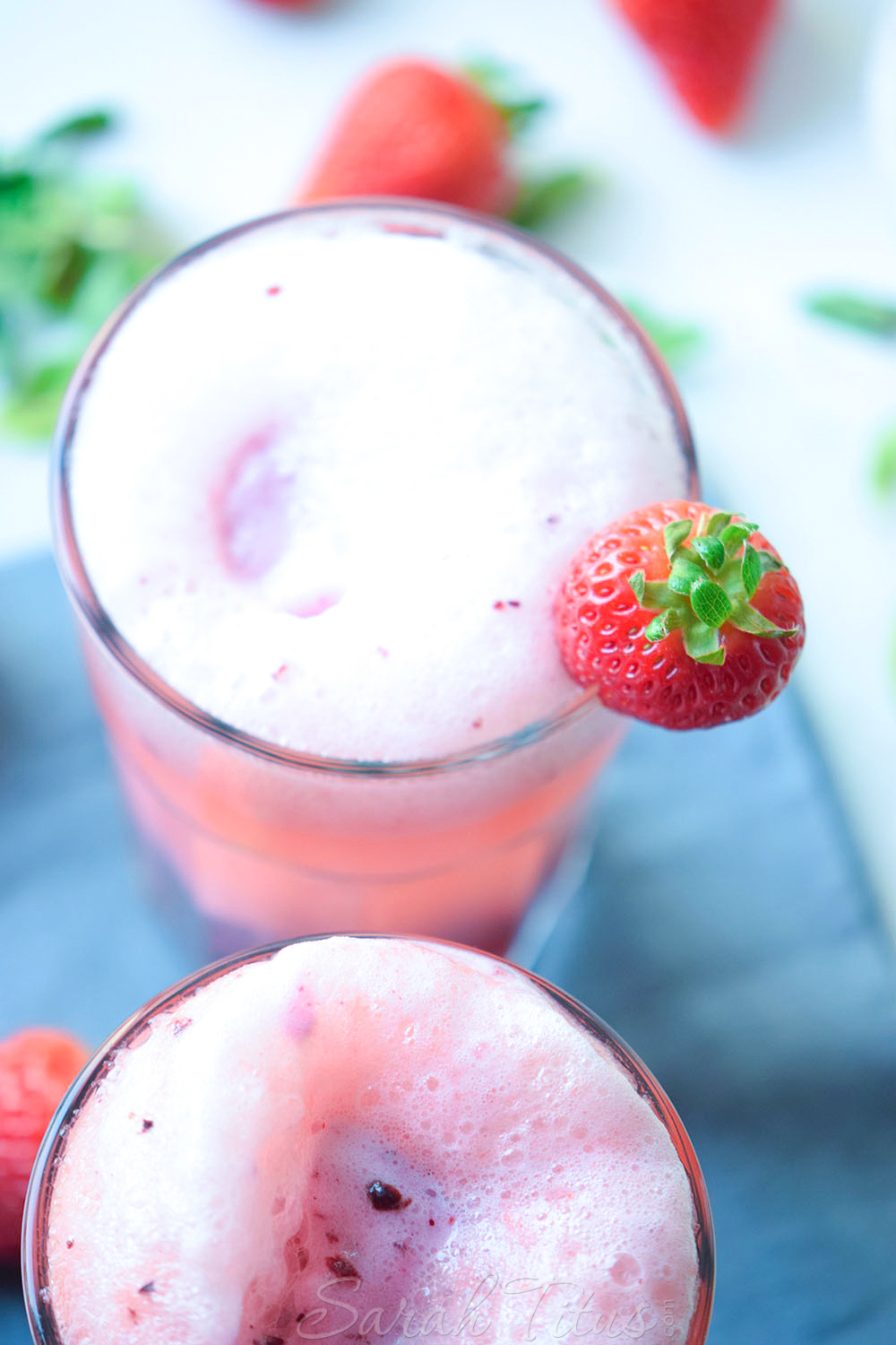 Topping the Very Berry Ice Cream Float with more ice cream and garnished with a fresh strawberry