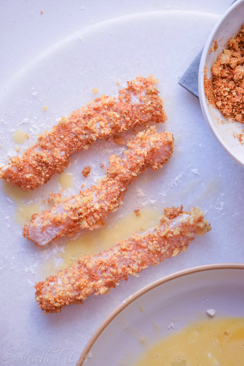 The sliced chicken pieces dipped in the breadcrumbs