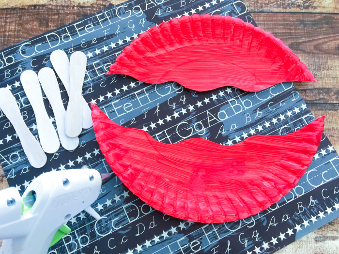 Cut painted paper plate in half with a wavy line