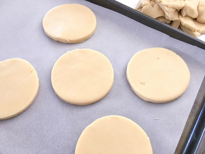 Apple Sugar Cookie dough rolled out and cut in circles laid on parchment lined cookie sheet