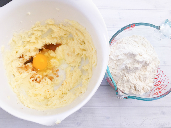 Adding egg and vanilla to Apple Sugar Cookie batter with flour on the side