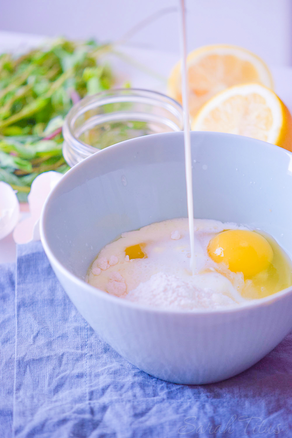 Adding milk to egg and flour in white bowl