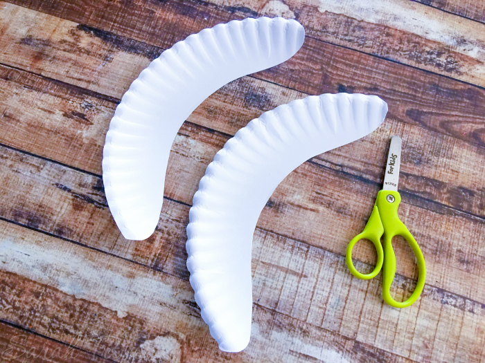 Scissors and the cut paper plate into banana shapes for the Pete and Cat banana craft 