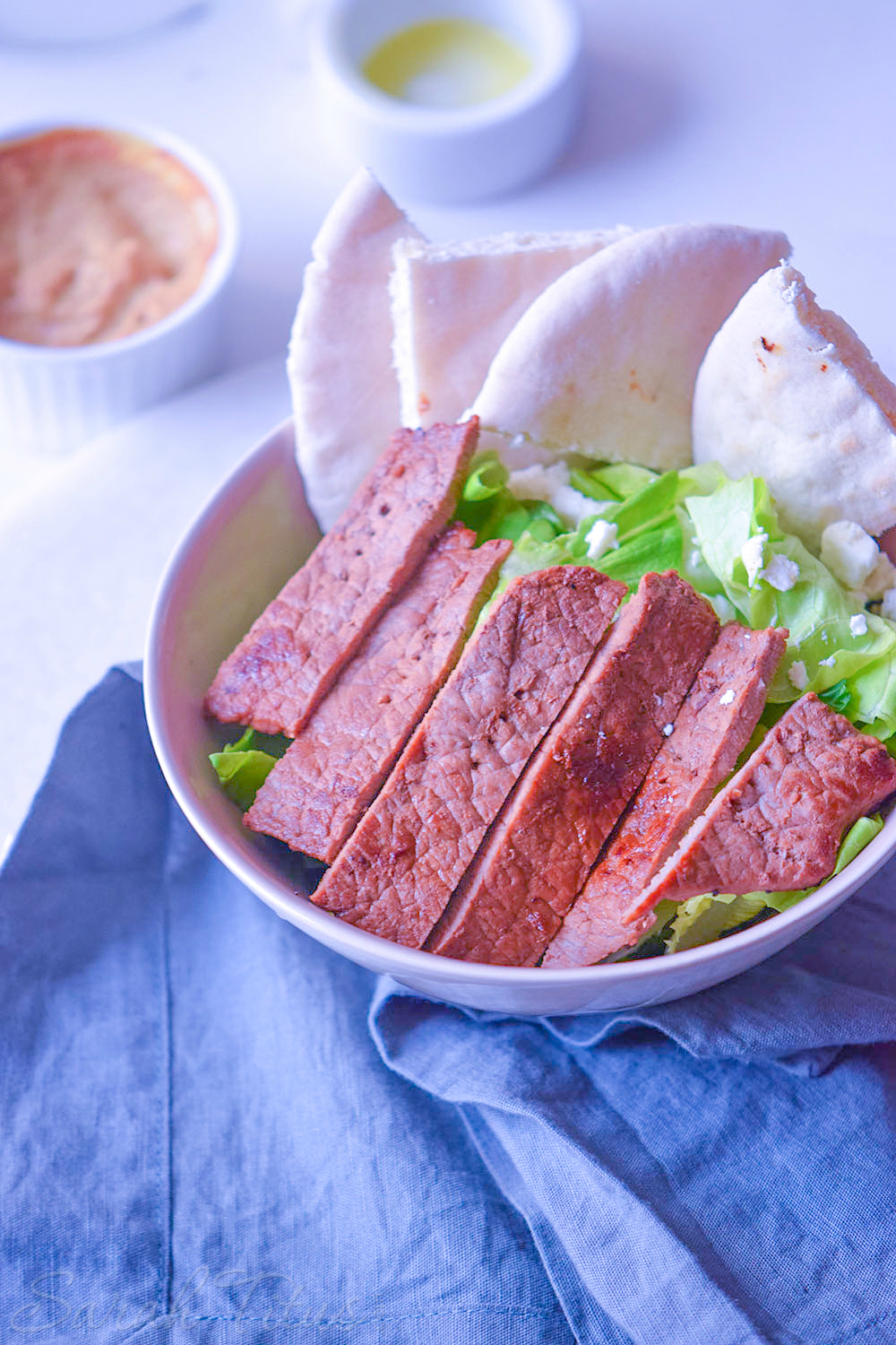 Lettuce, pita, Feta cheese and steak in a bowl for the Italian bowl