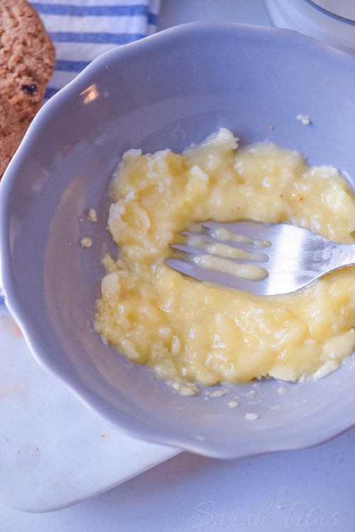 Mashing banana together with the milk in a blue bowl