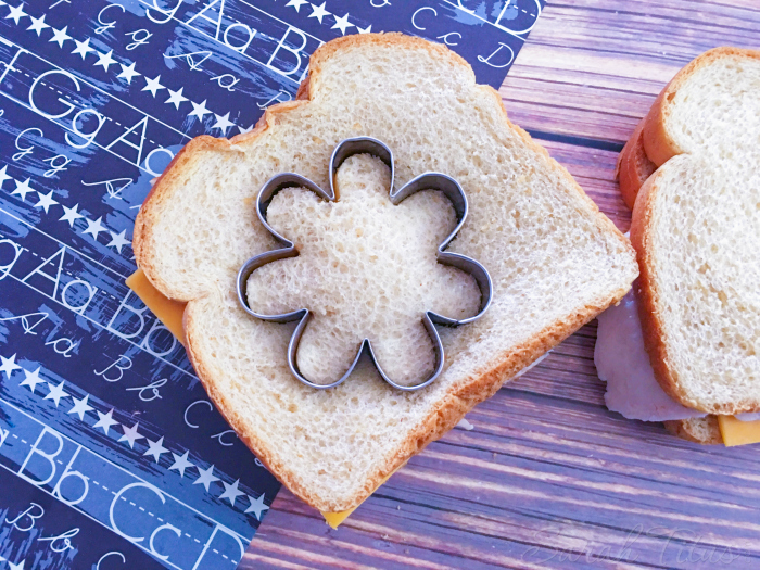 Cutting turkey and cheese sandwich with the flower shaped cookie cutter for the Flower Bento Box