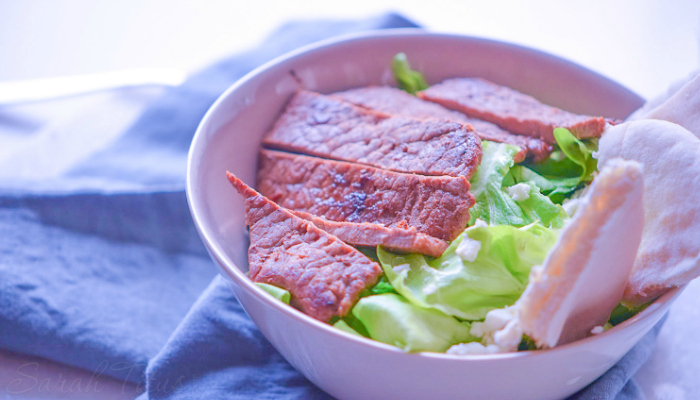 Colorful and delicious looking Italian bowl of pita bread, beef steak, salt, olive oil, Feta cheese and lettuce leaves