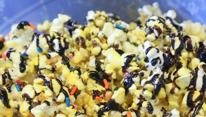 Birthday Cake Popcorn made with rainbow sprinkles and chocolate syrup in a large bowl