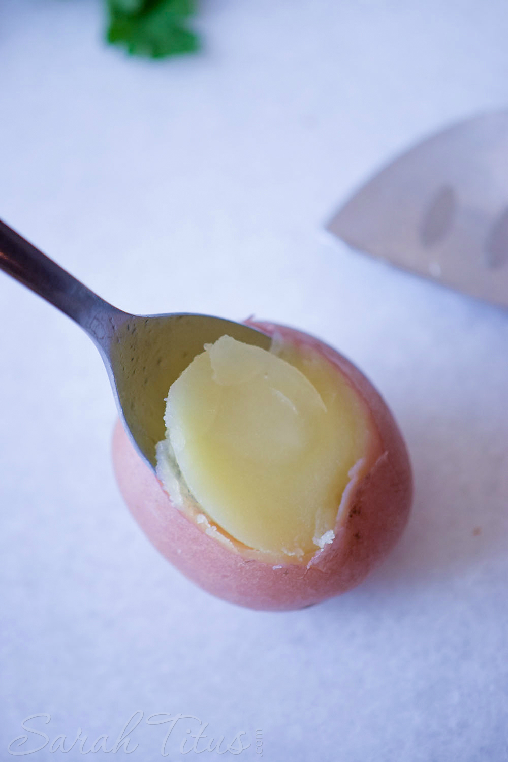 Spoon scooping out potato from the inside