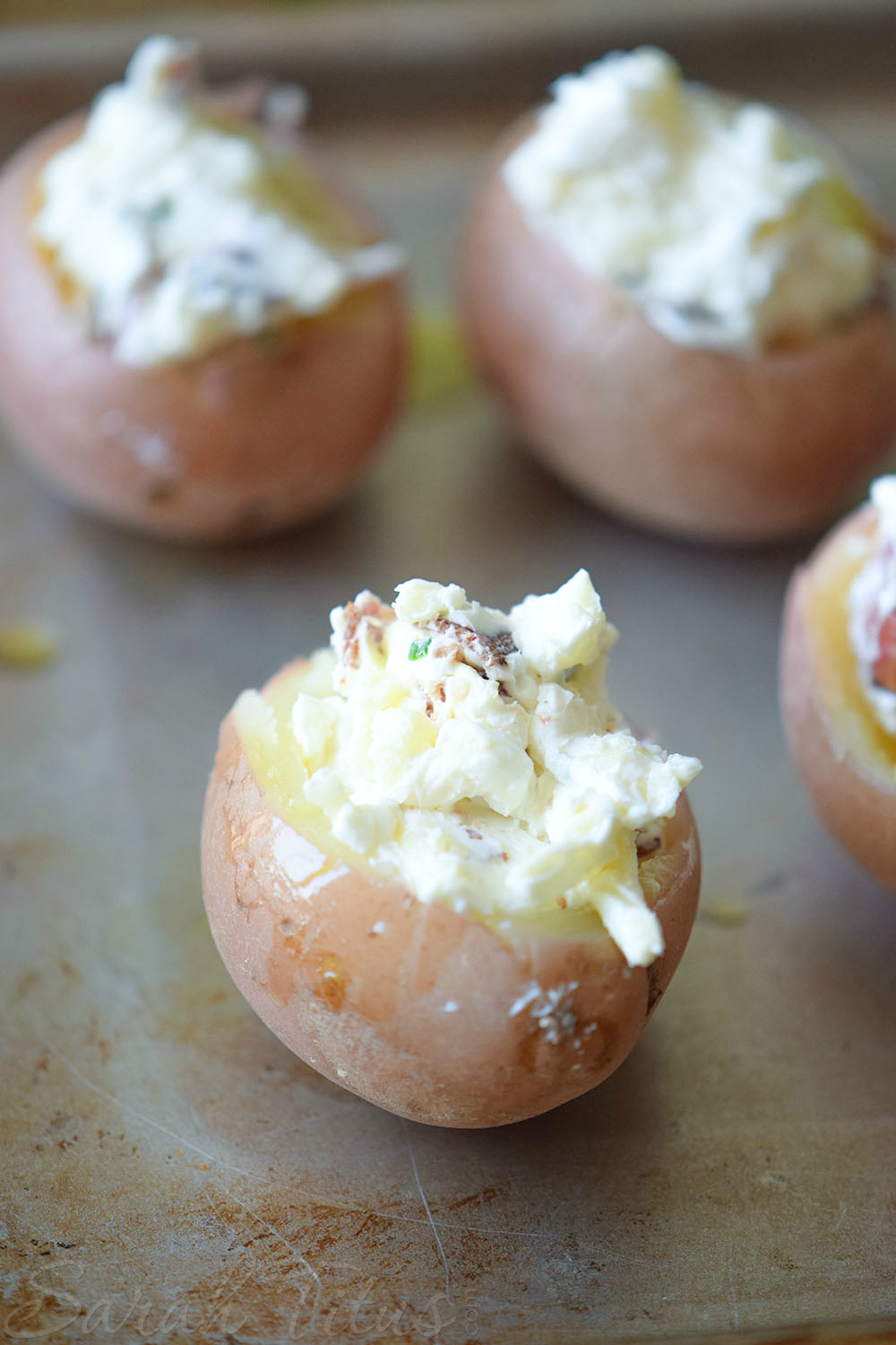 Mini Stuffed Potato Bites - Filling the red potatoes with the cheese mixture on a baking sheet