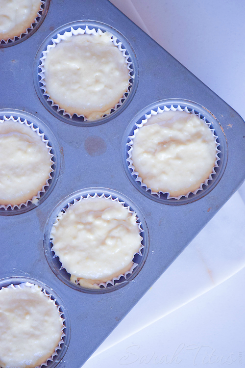 Muffin tin lined with white cupcake papers filled with Nutella Swirl Muffins batter