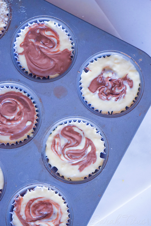 Metal muffin pan filled with Nutella Swirl Muffins batter