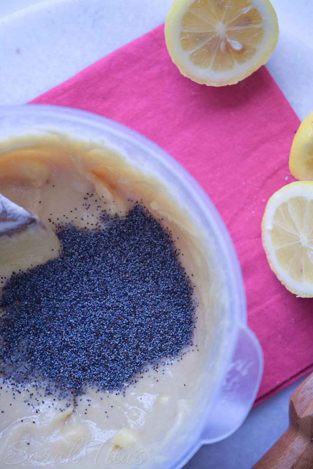 Stirring lemon poppy muffin batter and stirring in poppy seeds