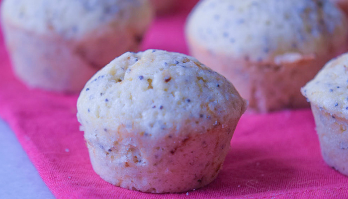 Freshly baked lemon poppy muffins on a pink cloth napkin