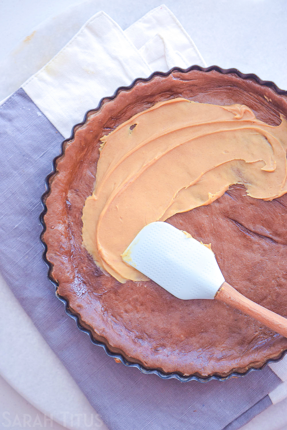 Spreading of peanut butter over the top of the chocolate and peanut butter pie crust.