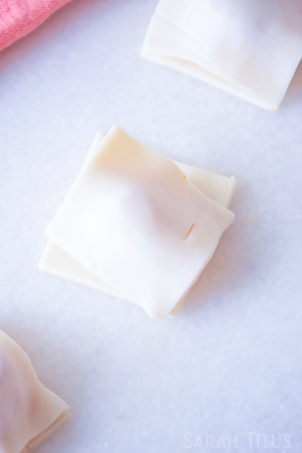 Topping puff pastry squares with ingredients inside with another puff pastry square