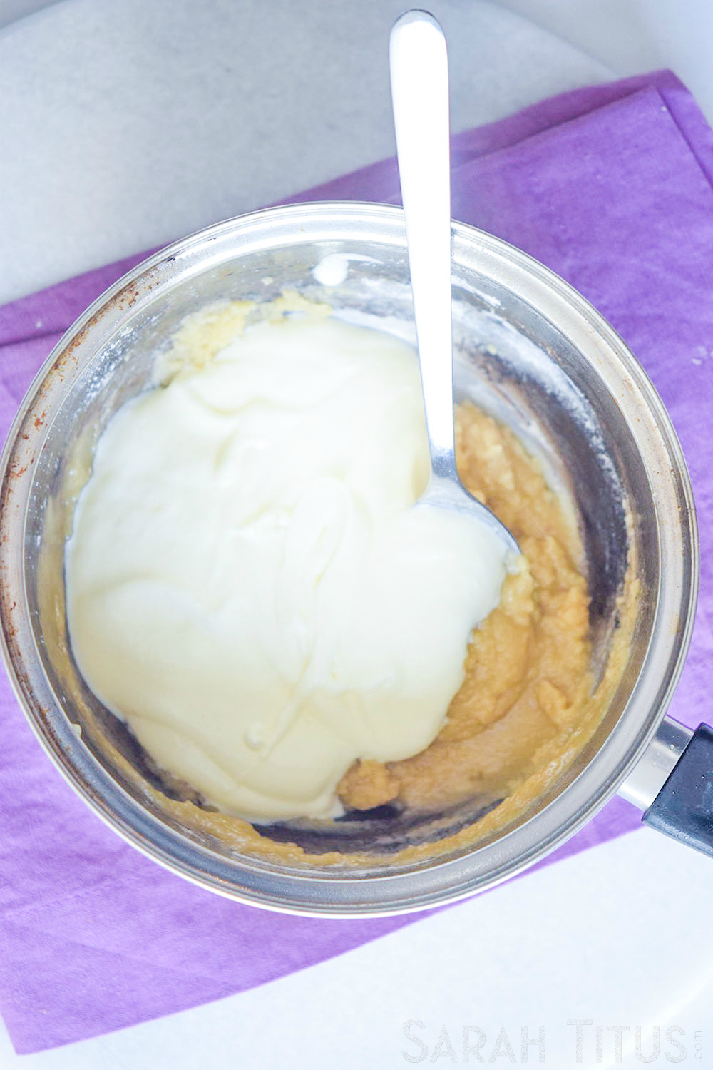 Adding flour and cream to a pan, stirring together to make potato soup