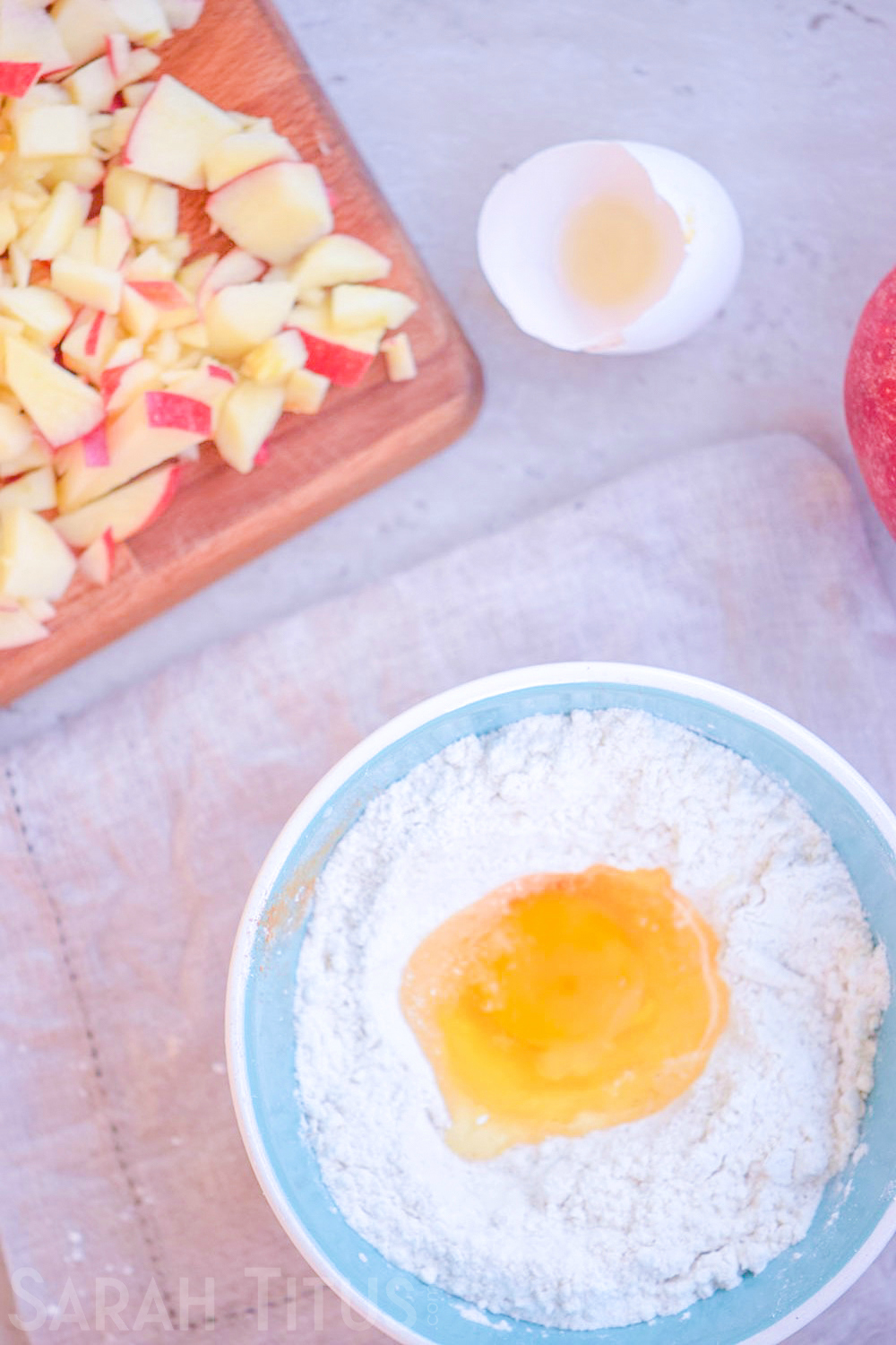 Adding an egg to the dry ingredients bowl for the baked apple doughnuts