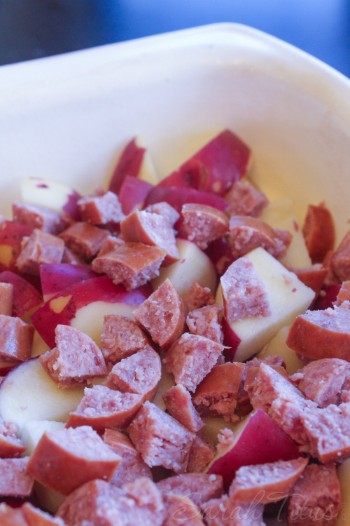 Adding chopped sausage to the Potato and Polish Sausage Bake.