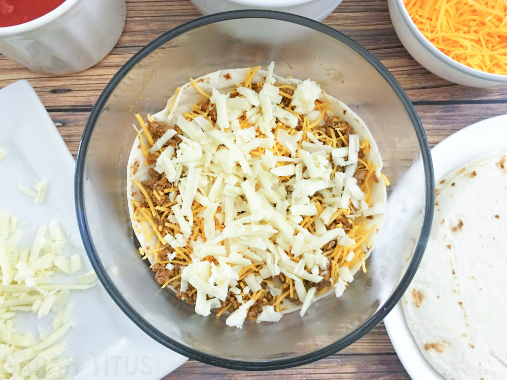 Ingredients for the taco bake: salsa, cheeses and tortillas with the beef, a tortilla and the cheeses layered on the bottom of a glass bowl