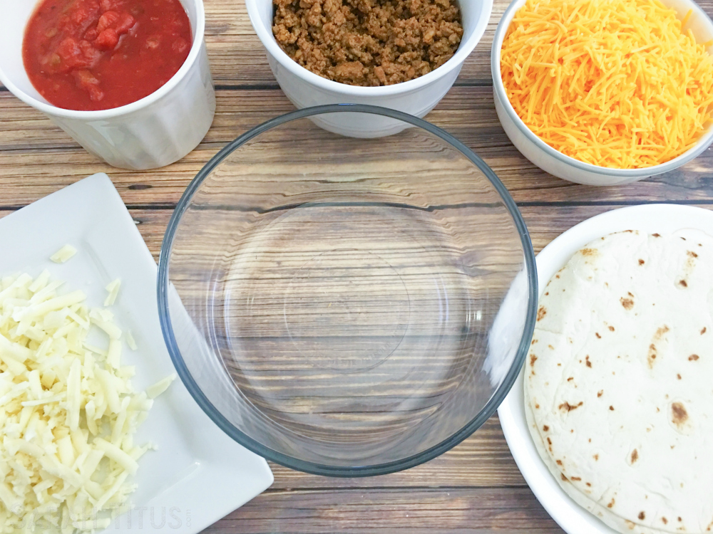 Ingredients for the taco bake: salsa, beef, cheeses and tortillas on a wooden table