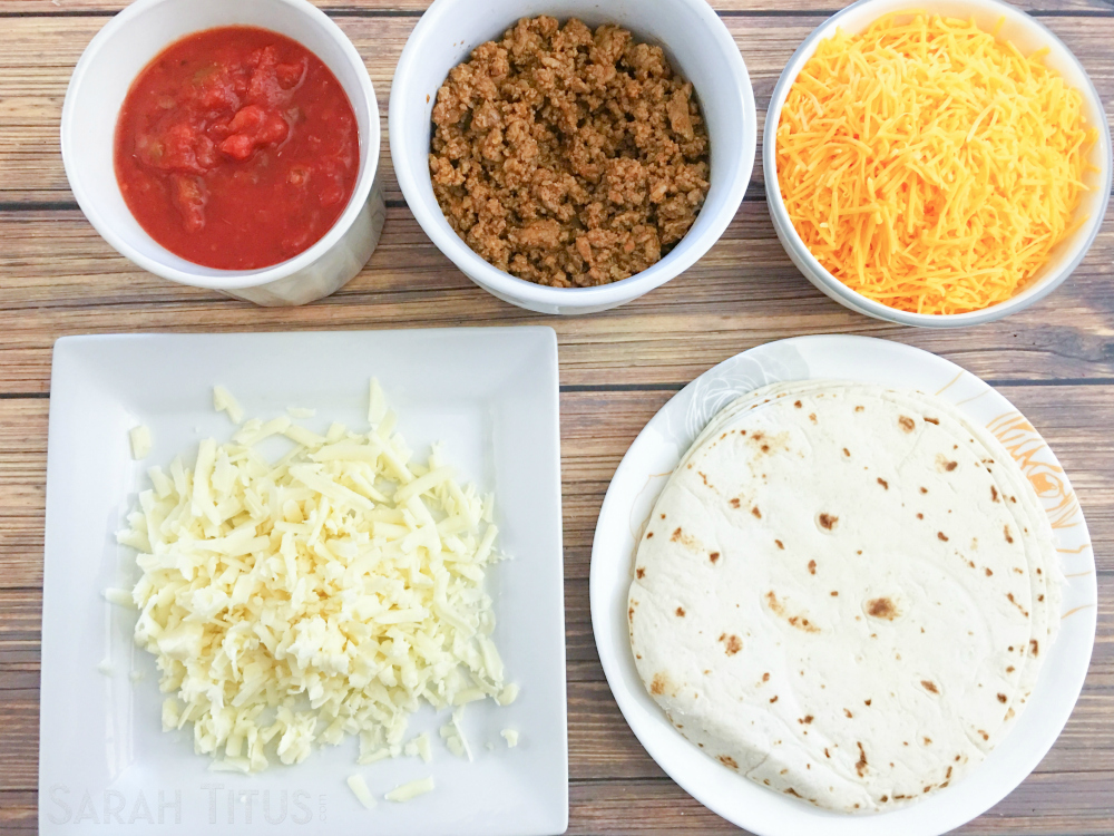 Ingredients for the taco bake: salsa, beef, cheeses and tortillas on a wooden table