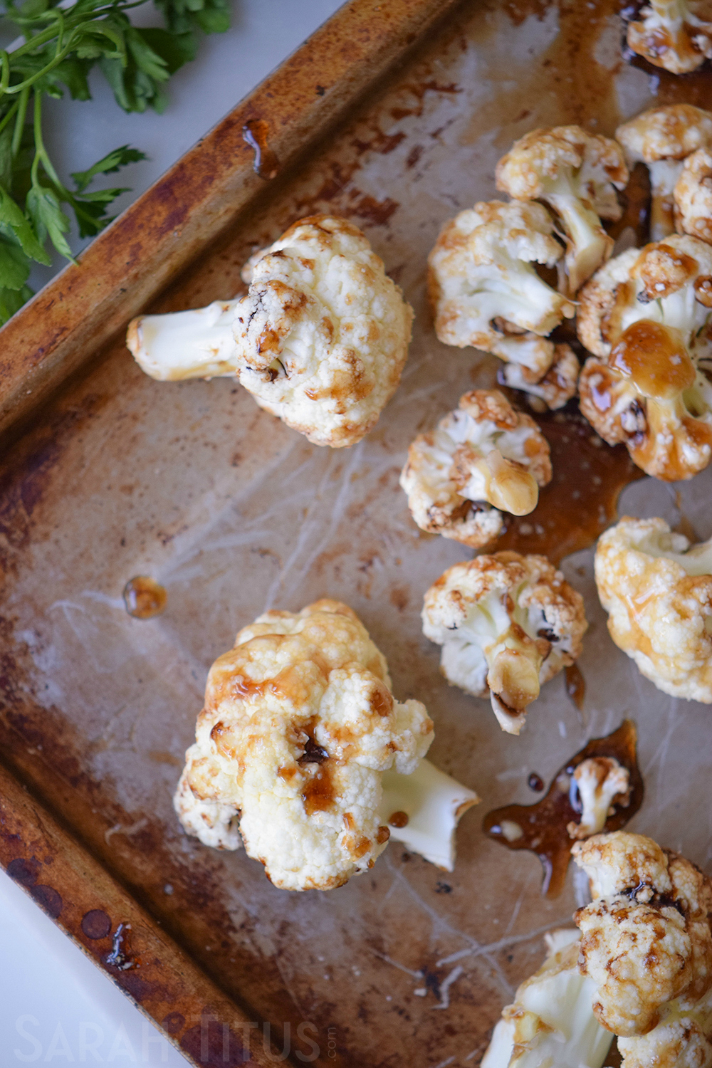 The sticky cauliflower bites spread out on a baking sheet ready to go in the oven