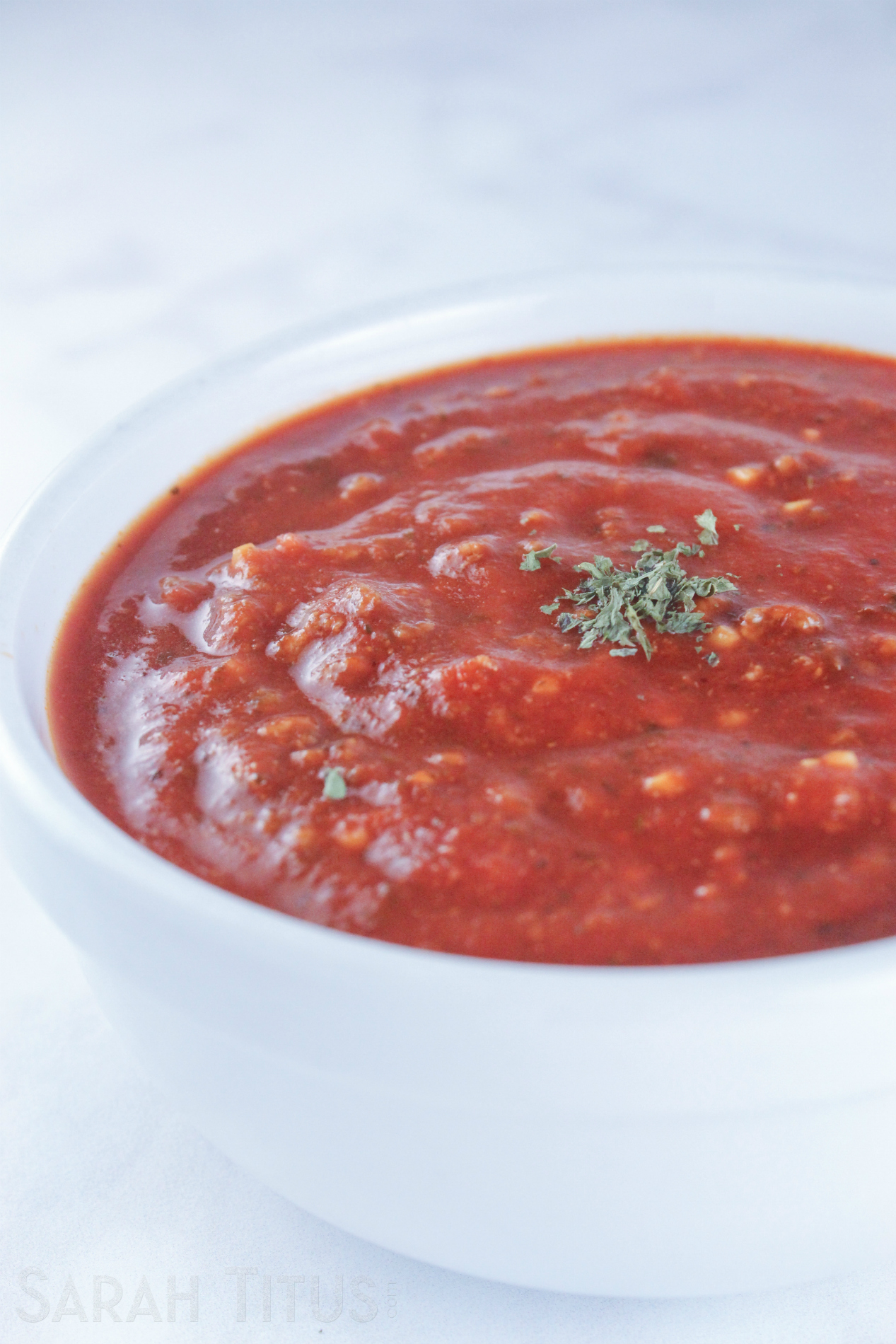 Luscious thick tomato sauce for pasta in a white bowl on a marble counter