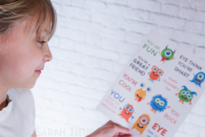 Child looking happily at adorable, colorful, printable monster Valentine's Day cards for kids