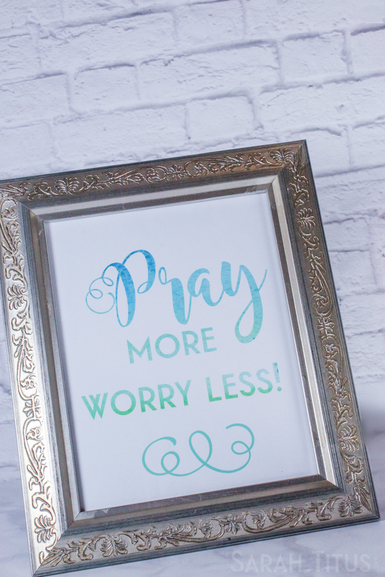 Pray More Worry Less framed printable against a brick wall