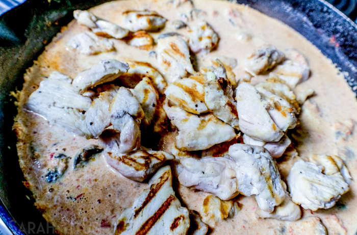 Adding cream and chicken to vegetable and mushroom mixture and cooking in a cast iron skillet