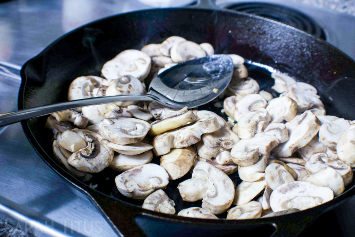 Sauteing mushrooms, olive oil and garlic in a cast iron skillet