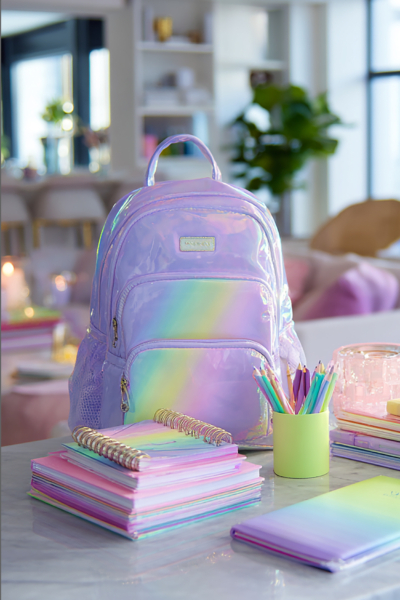 Iridescent pastel backpack with colorful school supplies, notebooks, and pencils on a modern table in a chic home.